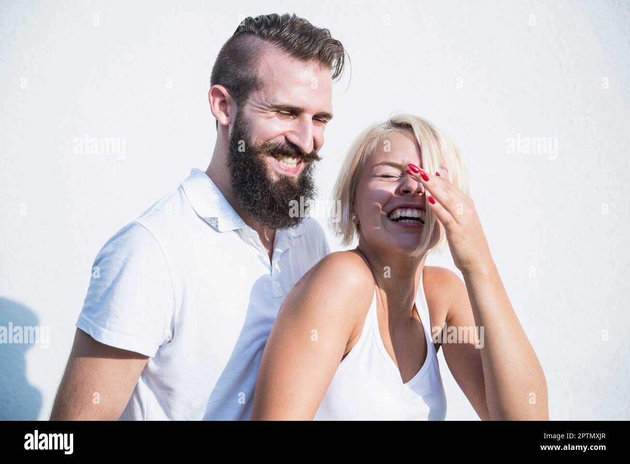Ein junges Paar, das vor der Wand lacht, Bayern, Deutschland Stockfoto