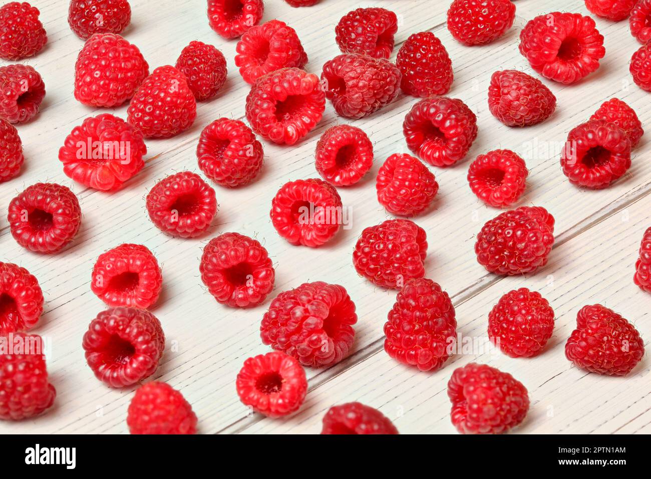 Himbeeren frisch gepflückt aus dem Garten auf White boards Schreibtisch verschüttet. Stockfoto