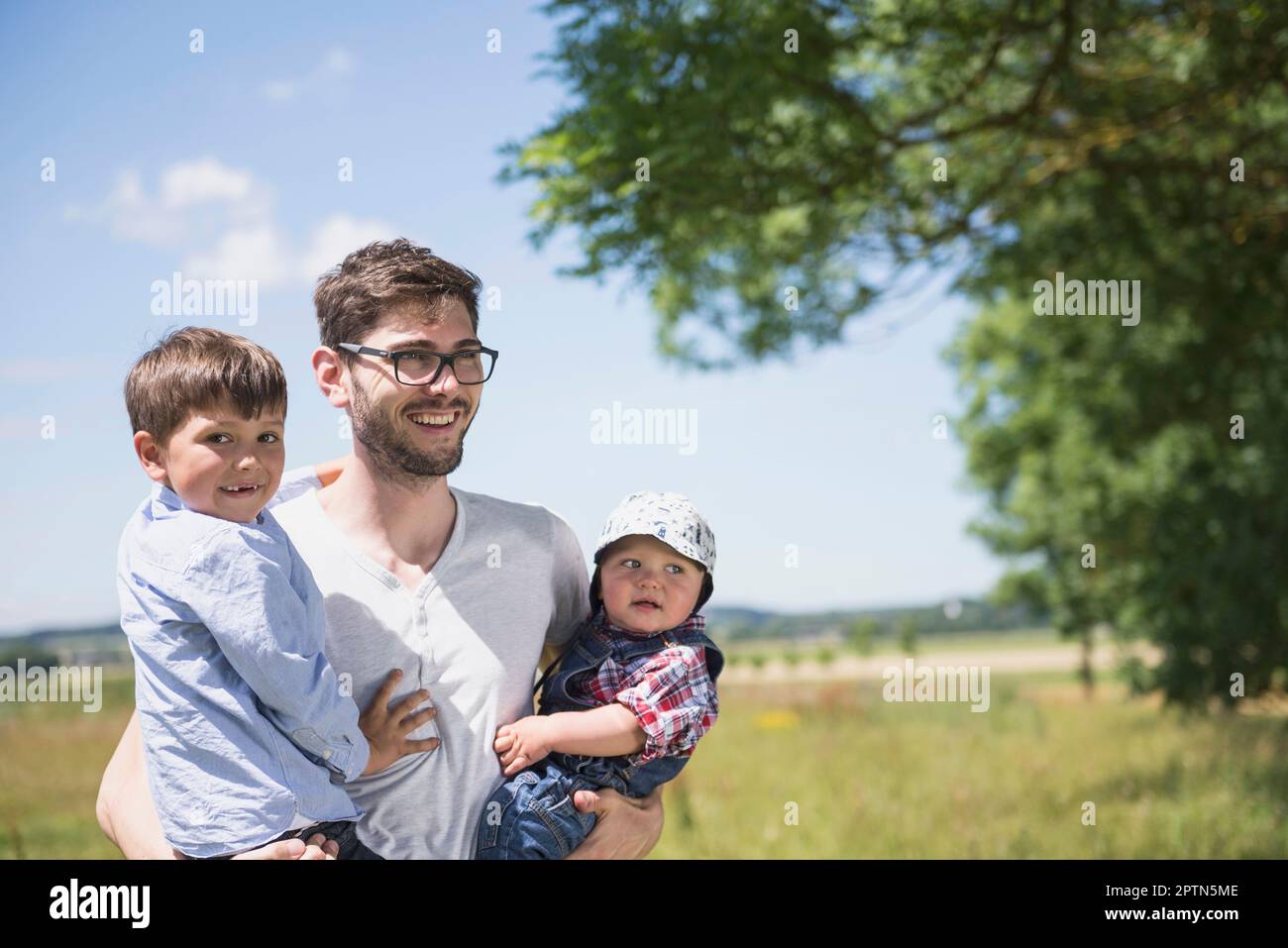Glücklicher Mann mit seinem Sohn, der ein Picknick auf dem Land in Bayern genießt Stockfoto
