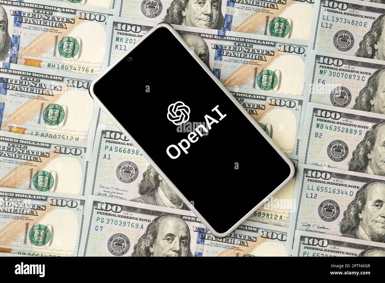 openai-Logo auf dem Smartphone-Bildschirm und daneben US-Dollarscheine. Draufsicht. Konzeptfoto. 30. März 2023. Barnaul. Russland. Stockfoto