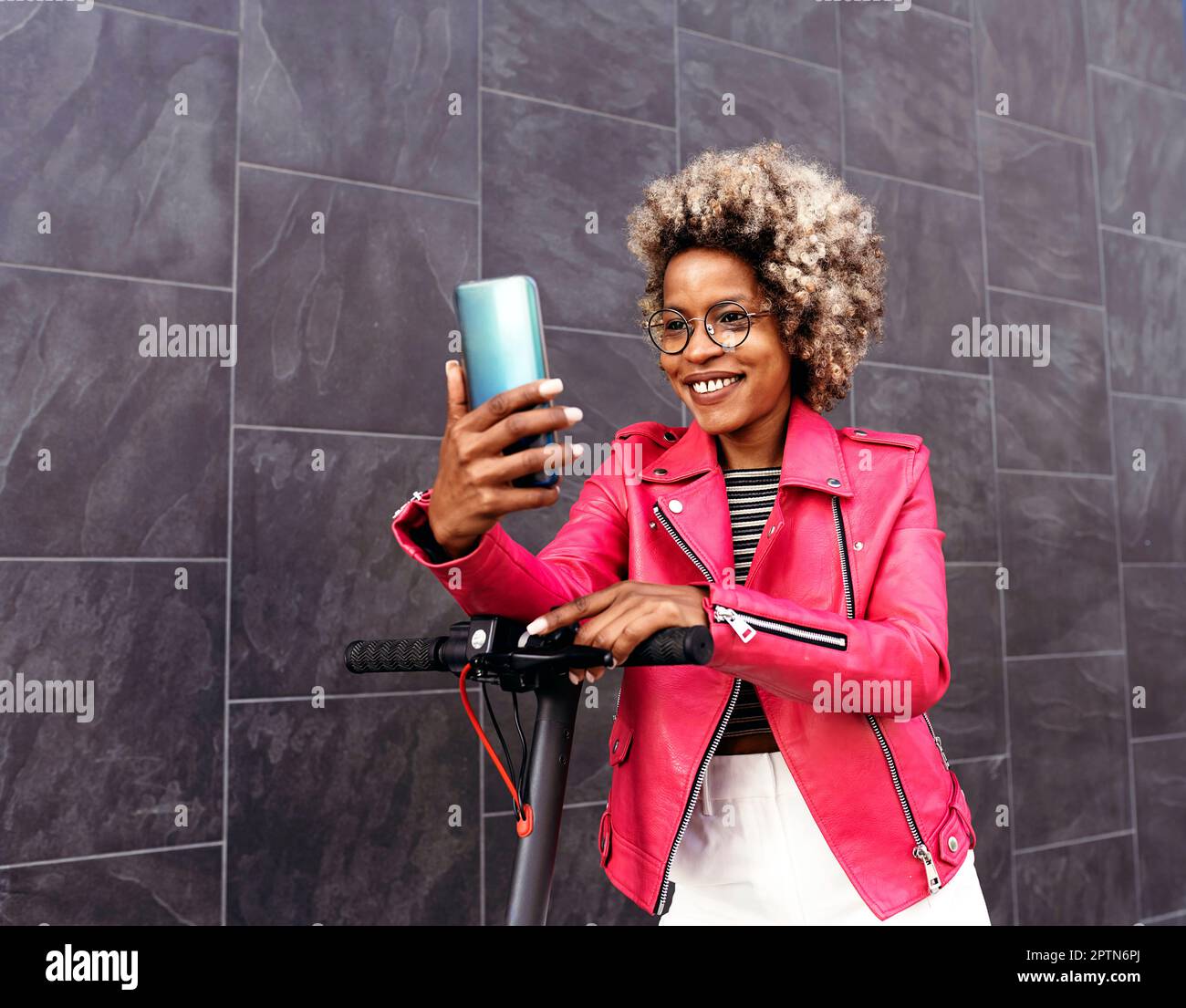 Eine afroamerikanische Frau, die das Handy auf der Straße benutzt Stockfoto