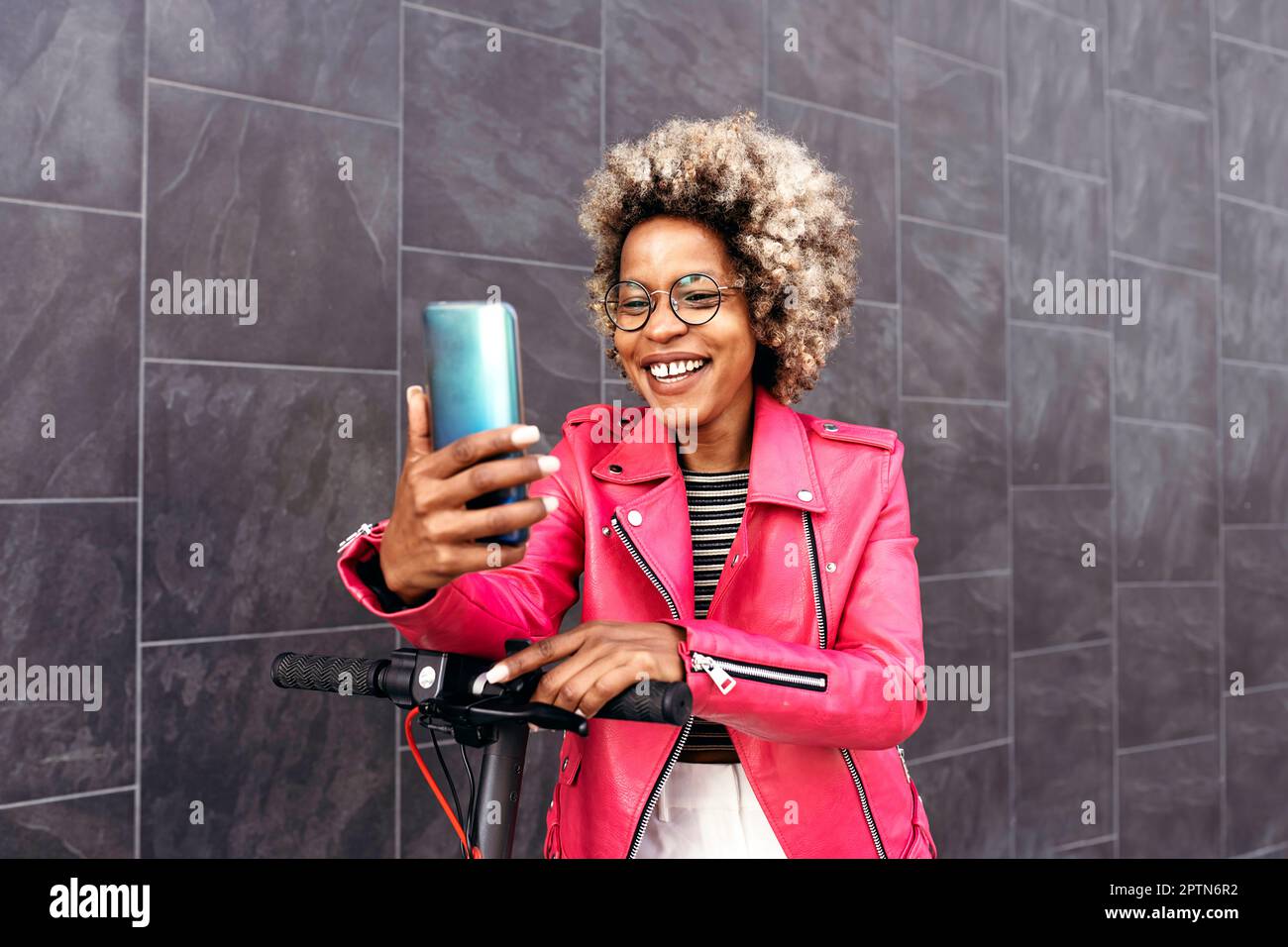 Eine afroamerikanische Frau, die das Handy auf der Straße benutzt Stockfoto