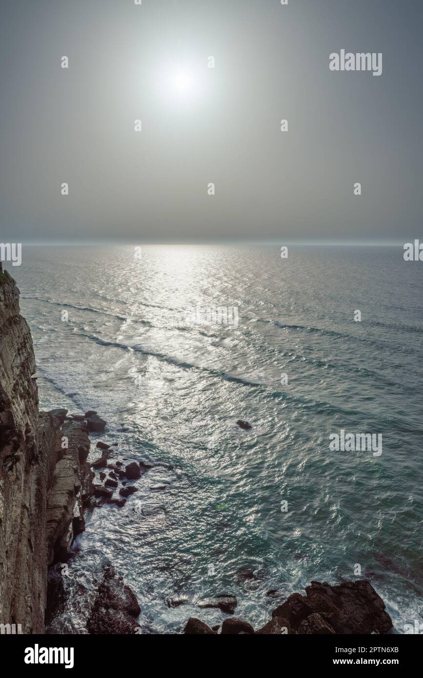 Felsige Küste, Meer und Sonnenlicht scheinen durch Wolkenlücken. Wunderschöner Naturhintergrund. Stockfoto