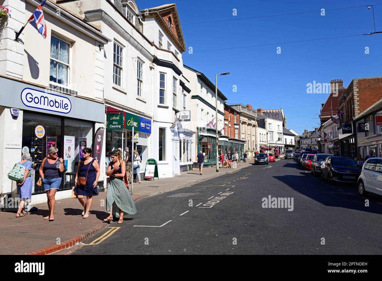 Blick auf die Einkaufsstraße High Street im Stadtzentrum mit Shoppers zu Fuß, Sidmouth, Devon, Großbritannien, Europa. Stockfoto
