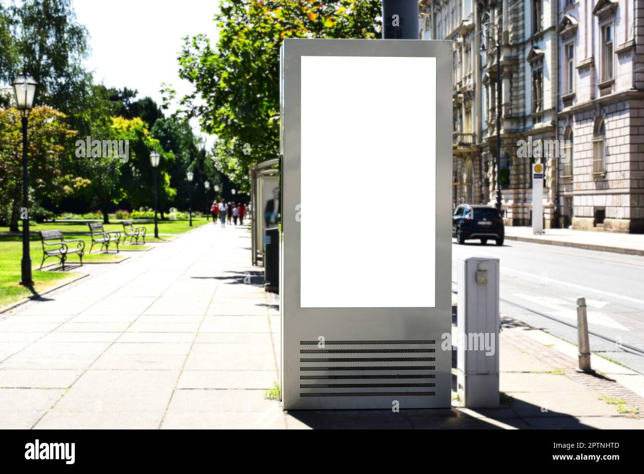 Leere weiße Anzeige und Werbetafel. Modellbasis. Leerer Posterhintergrund. Weicher urbaner grüner Hintergrund. Anzeigenbereich im vertikalen Format. Stockfoto