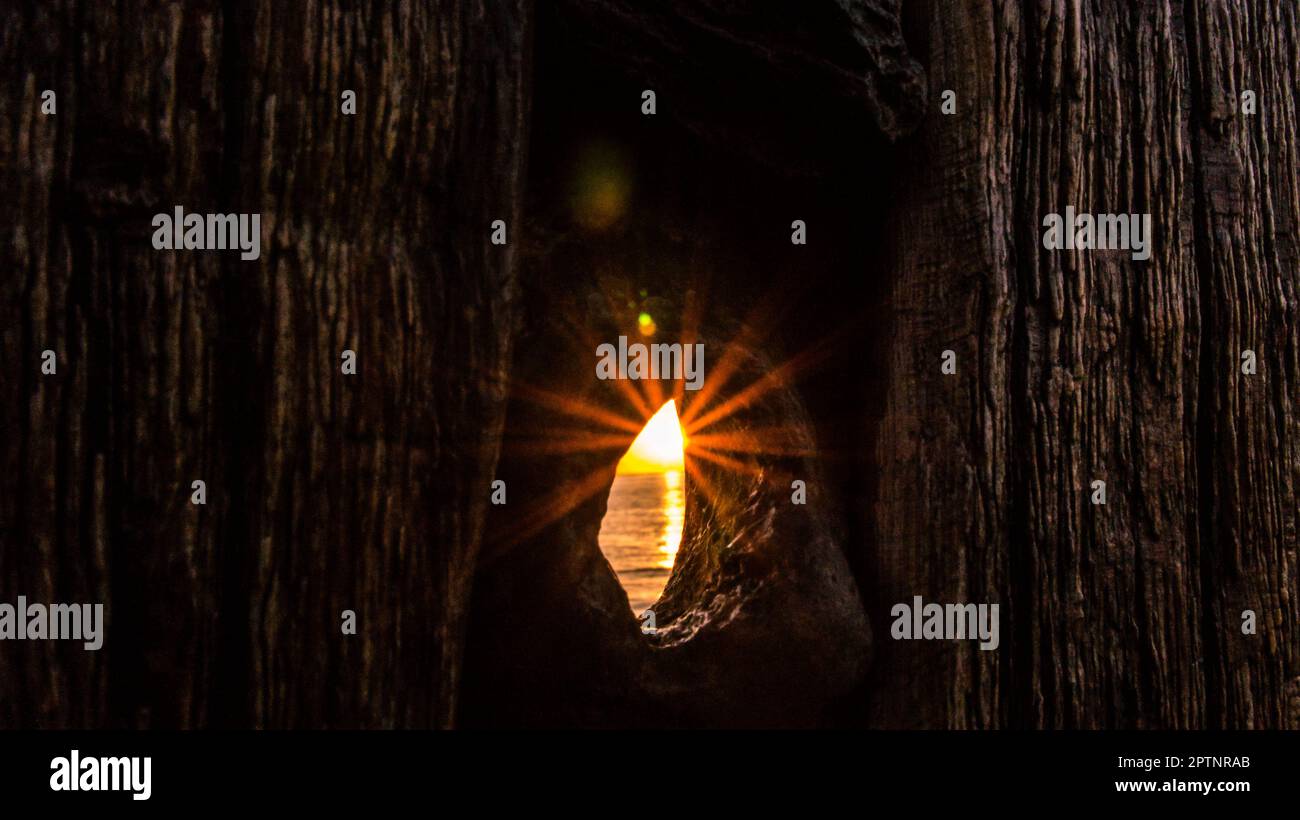 Sonnenstrahlen, die durch ein Loch in der Boje leuchten. Am Ostseestrand bei Zingst Stockfoto