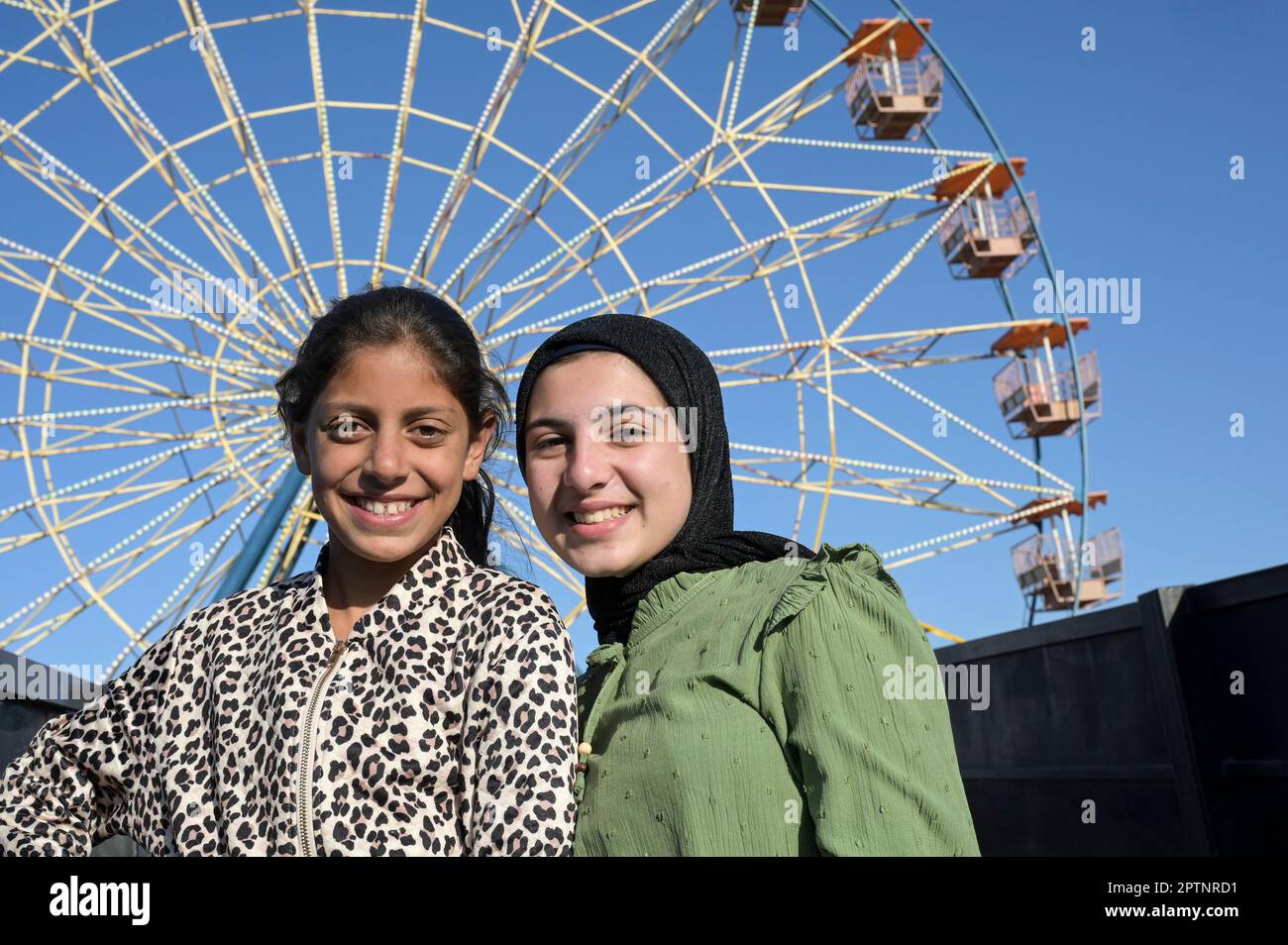 PALÄSTINA, Dschenin, die Menschen genießen nach dem Ende des Ramadan eine Kirmes, zwei palästinensische Mädchen vor den Fähren Wheel / PALÄSTINA, Jenin, Jahrmarkt Freuden nach dem Ende des Ramadan Fastenmonat Stockfoto