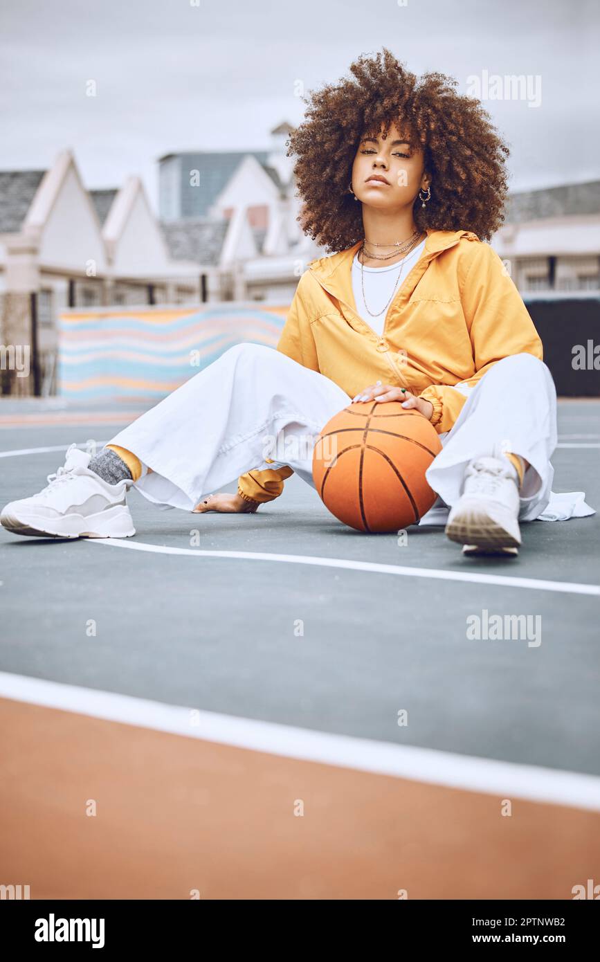 Basketball-, Platz- und Sportfrauenporträts, während Sie mit dem Ball  sitzen. Stylische, trendige und Afro-Lady sieht in sportlicher Kleidung  cool aus. Lässiges weibliches Modell für Fo Stockfotografie - Alamy