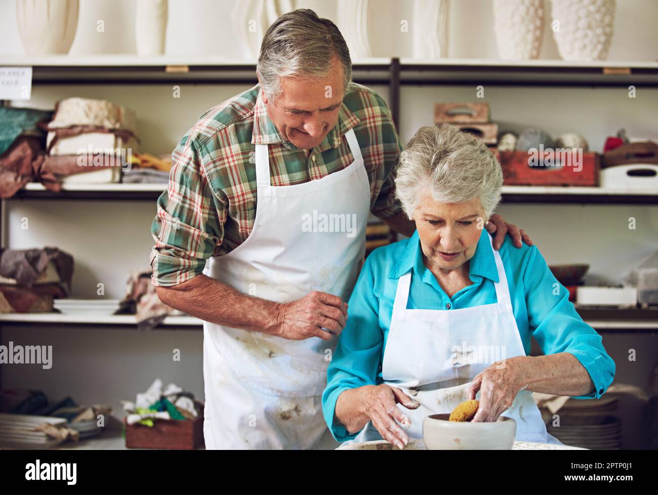 Es ist nie zu spät, ein neues Hobby zu lernen. Ein Seniorenpaar, das in einer Werkstatt einen Keramiktopf macht. Stockfoto