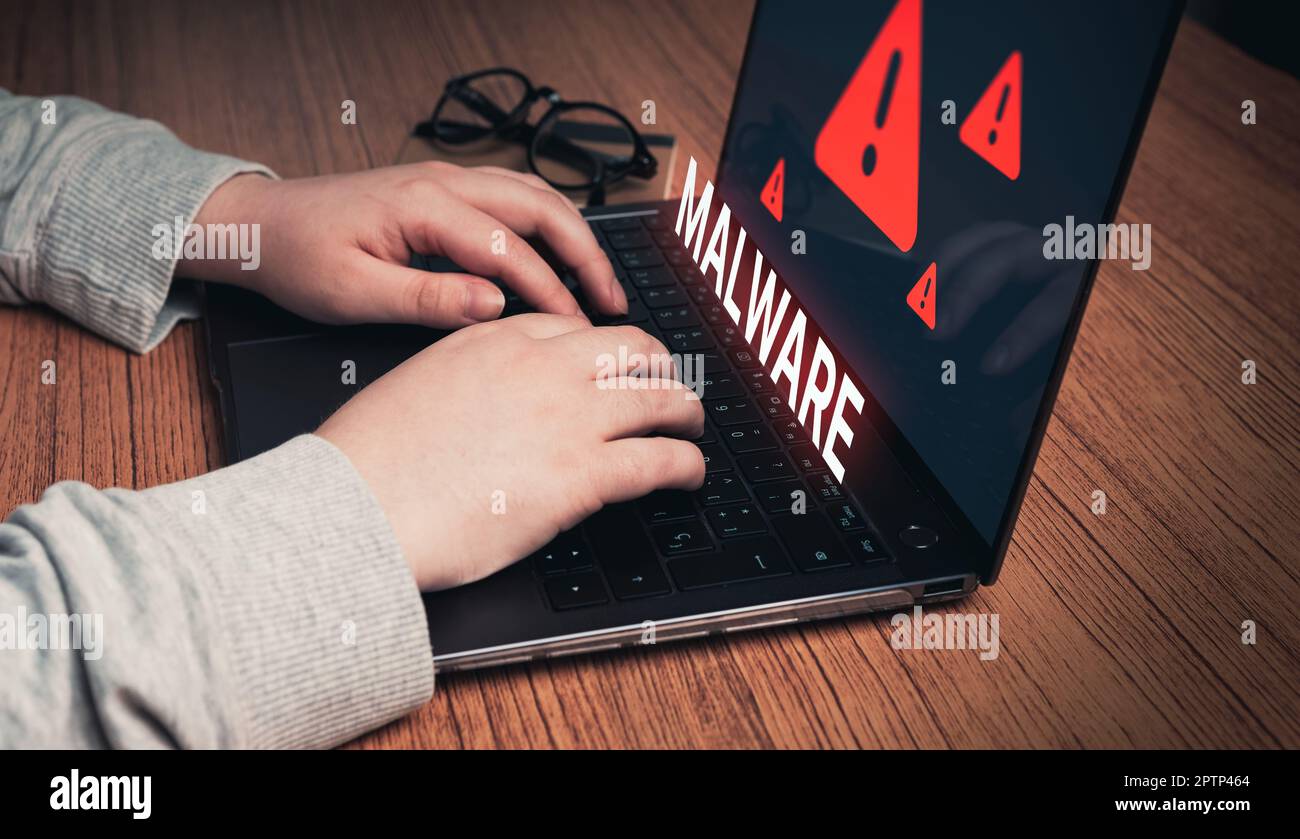 Frau, die ein Notebook mit virtueller Malware-Warnung verwendet. System-Hacker-Konzept. Cyberangriffe auf Computernetzwerke, Viren, Spyware, Malware oder schädliche Software. Stockfoto