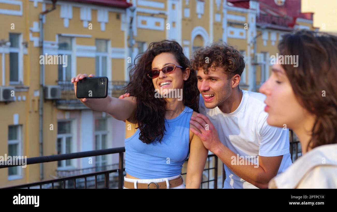 Nahaufnahme eines glücklichen jungen Paares, Freund und Freundin, die Selfie-Fotos auf einem Smartphone machen, draußen auf einer Party auf dem Dach stehen. Sommeruntergang. Menschen Stockfoto