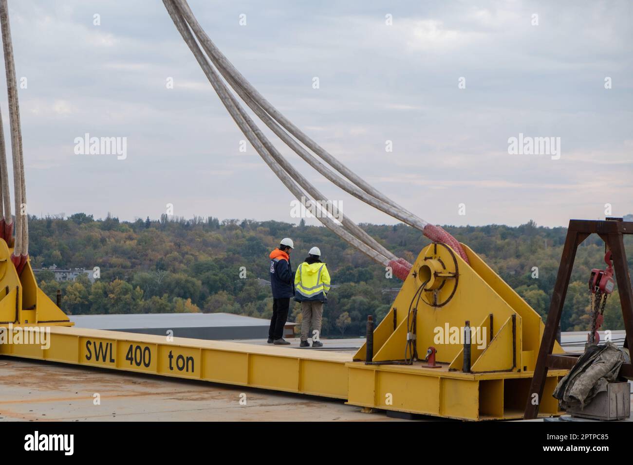 Ingenieur und Arbeiter prüfen Projekt auf Baustelle im Hintergrund des Flusses, Teil einer großen Baustelle. Stockfoto