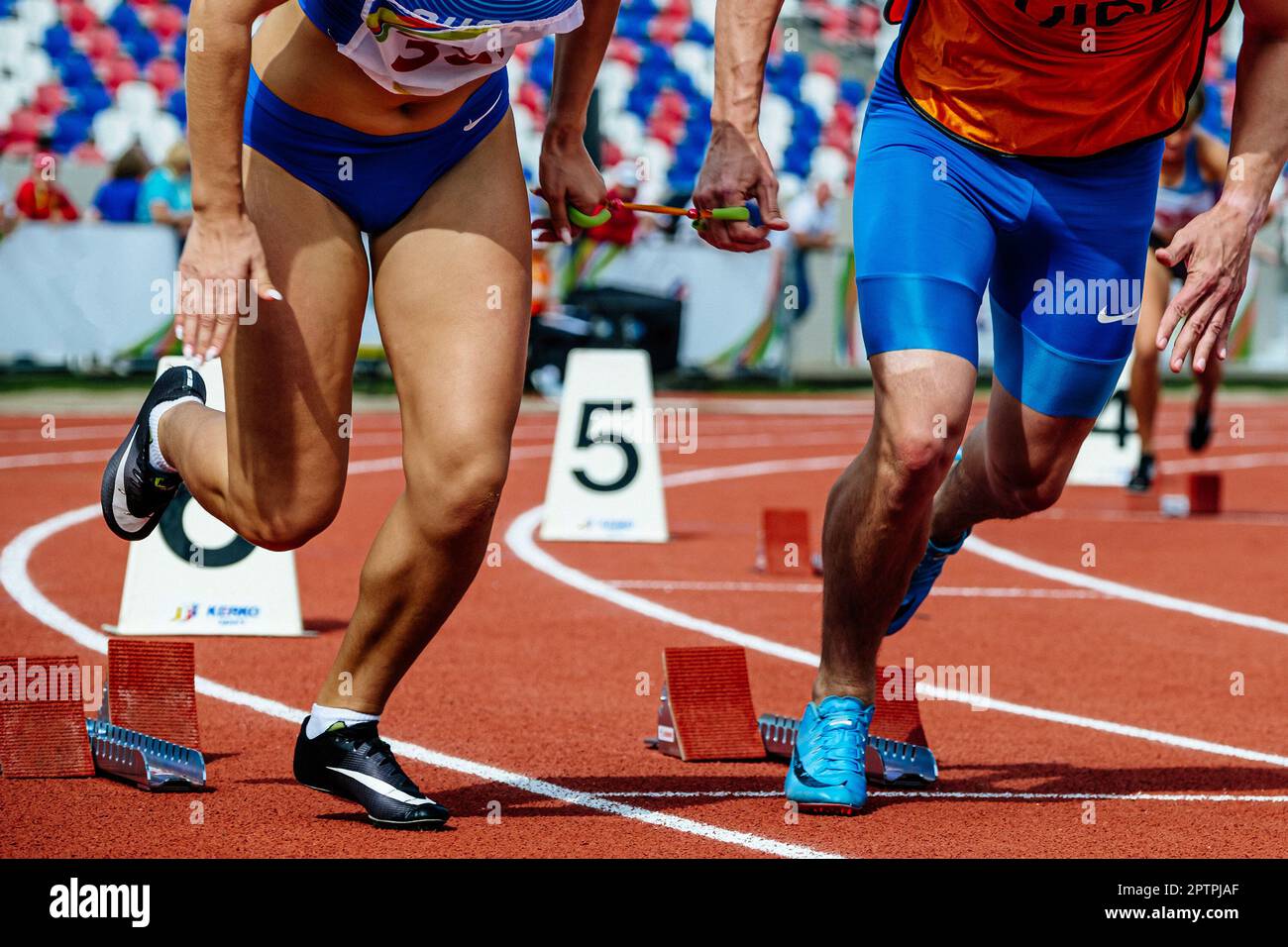 Blinde para-Sportlerin mit männlichem Reiseleiter beginnt das Rennen, Nike Brand Running Spikes Schuhe und blaue Shorts und Strumpfhosen Stockfoto