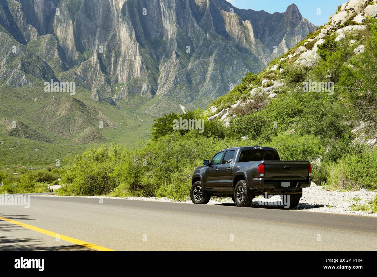 Schwarzes Auto in der Nähe von wunderschönen Bergen und Straßen im Freien Stockfoto