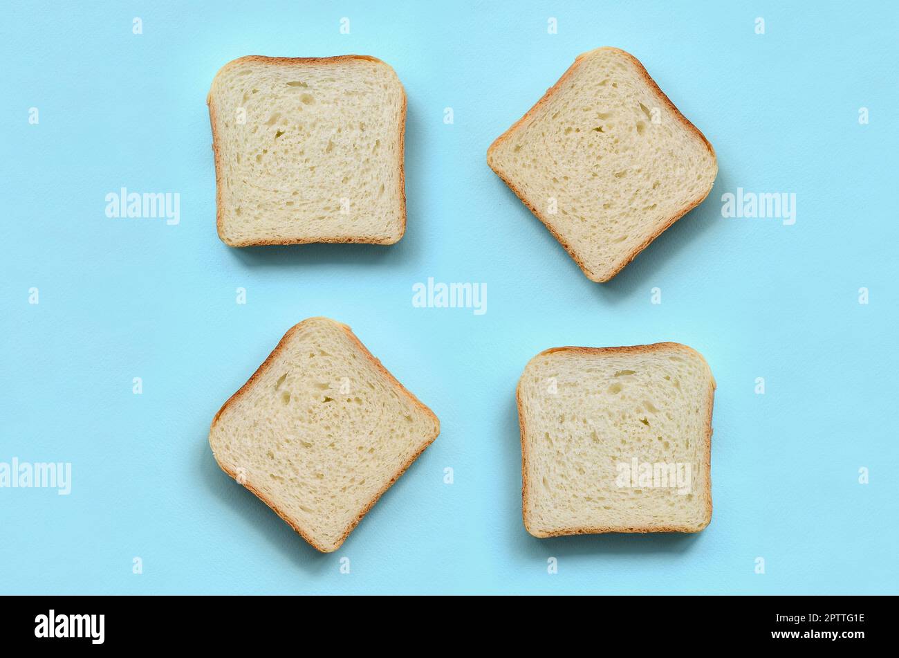 Ein paar Stücke Brot liegt auf Textur Hintergrund der Mode pastell-blaue Farbe Papier in minimalen Begriff. Stockfoto