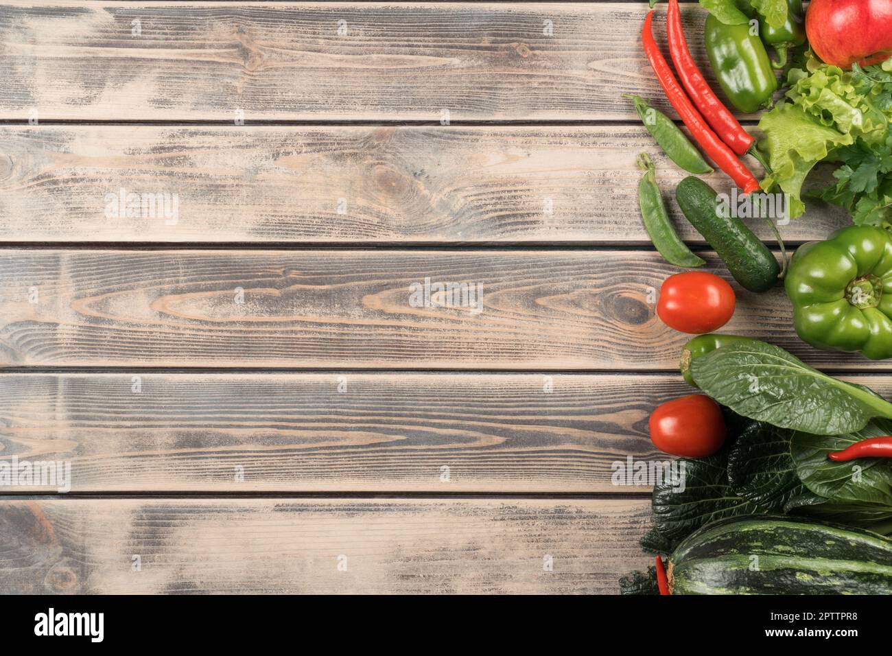 Grünes und rotes Lebensmittelmix-Layout des Sortiments von saftigem Bio-Gartengemüse auf Holzhintergrund. Paprika, Chili, Tomaten, Gurken und Kürbis. B Stockfoto