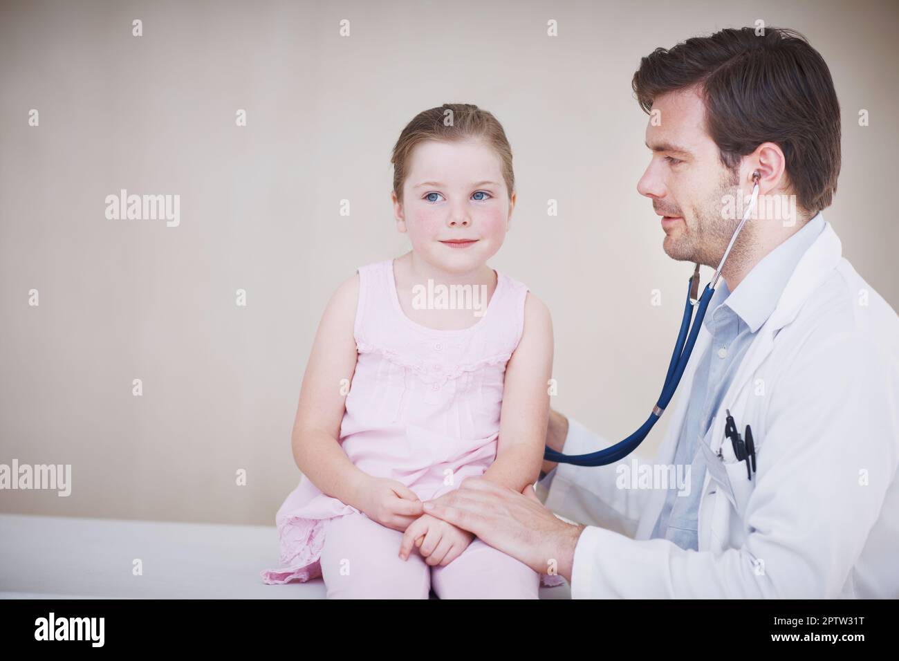 Nur eine kurze Untersuchung. Ein männlicher Arzt, der eine allgemeine medizinische Untersuchung eines kleinen Mädchens mit seinem Stethoskop durchführt Stockfoto