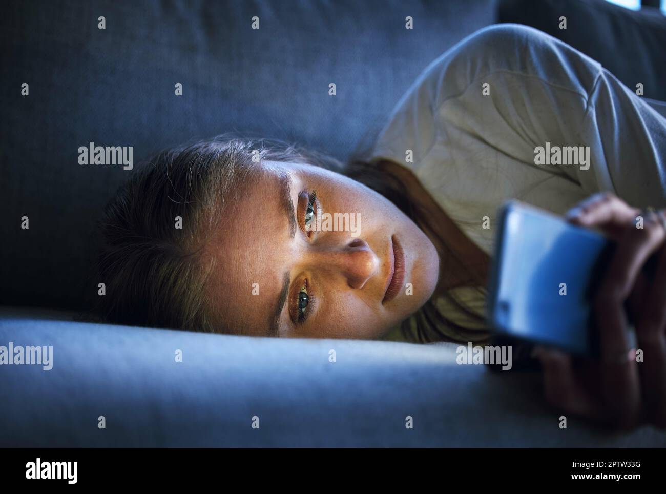 Telefon, Nacht und traurige Frau entspannen sich auf dem Sofa im