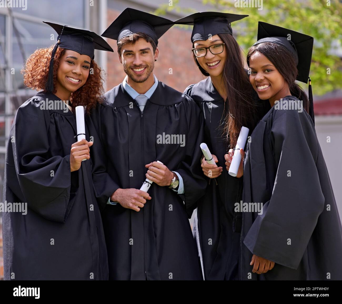 Unsere Zukunft auf harter Arbeit aufbauen. Lächelnde Universitätsstudenten am Abschlusstag Stockfoto