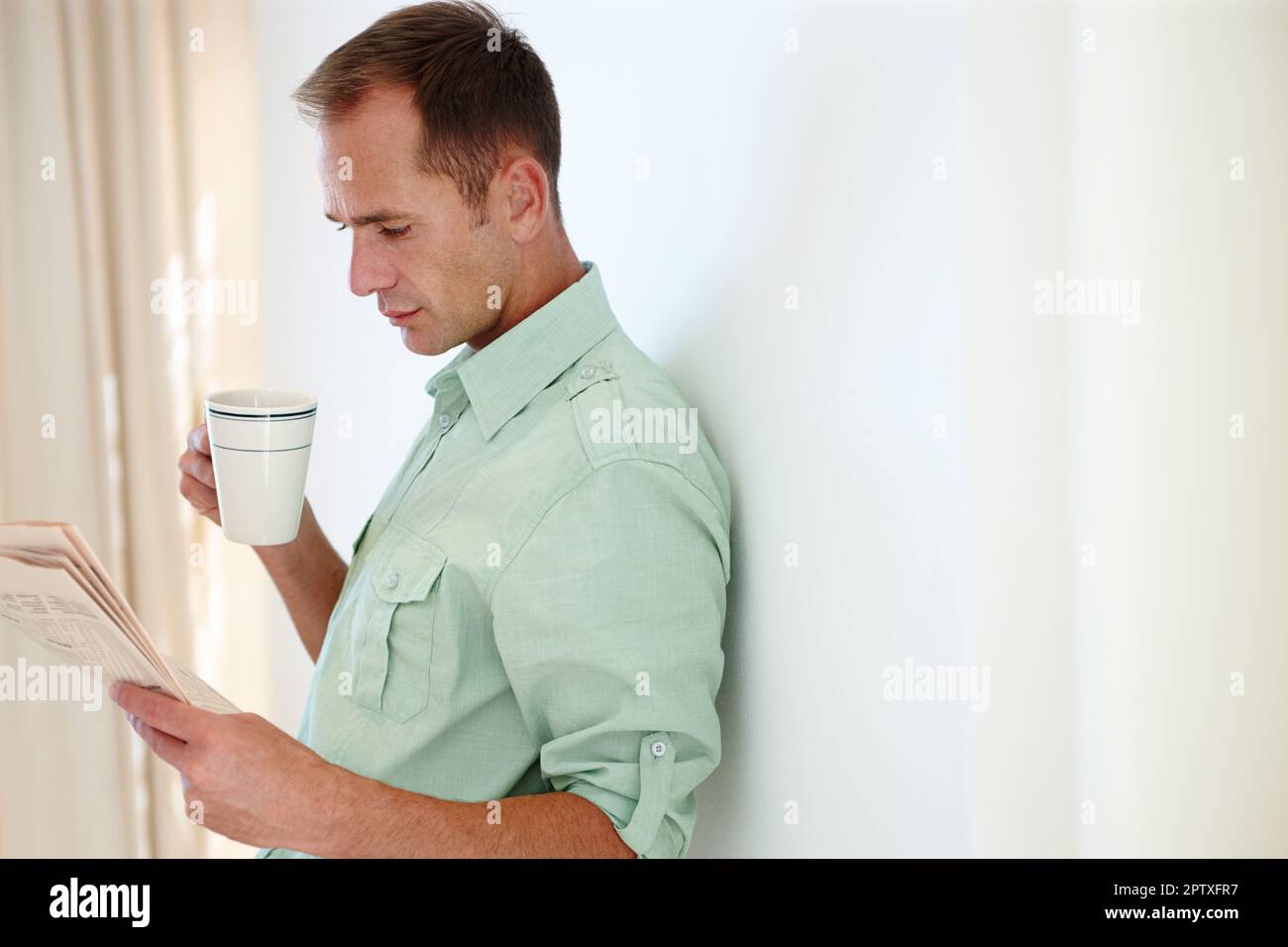 Bereit für die Nachrichten. Ein professioneller Mann, der Zeitung liest und Kaffee trinkt Stockfoto