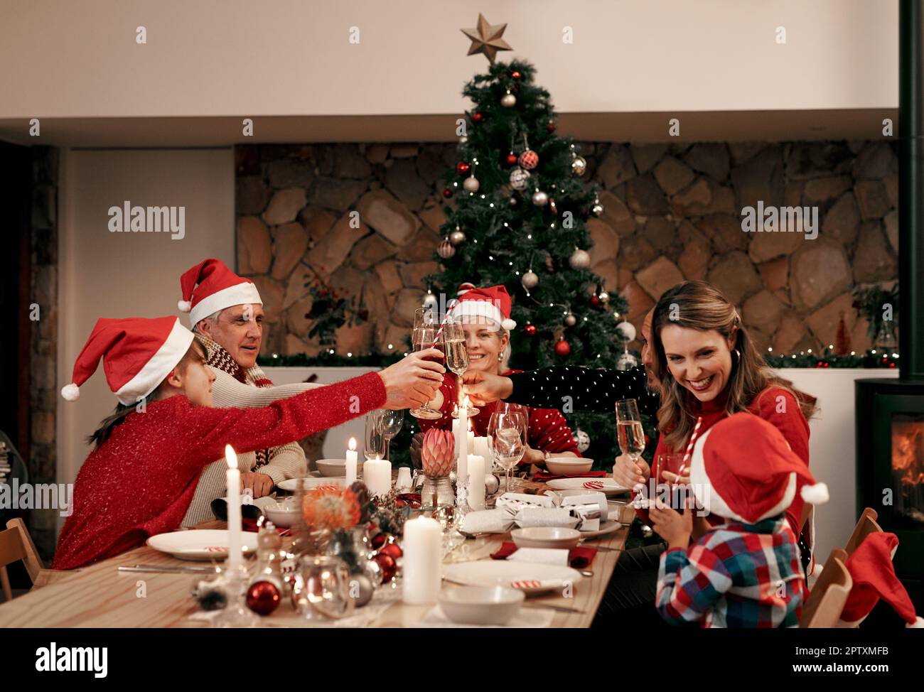 Weihnachten, Speisen und Toast mit der Familie an einem Tisch für Feiern, Feste und Veranstaltungen. Wein, Baum und Party mit Eltern und Kindern im Urlaub mit oma Stockfoto