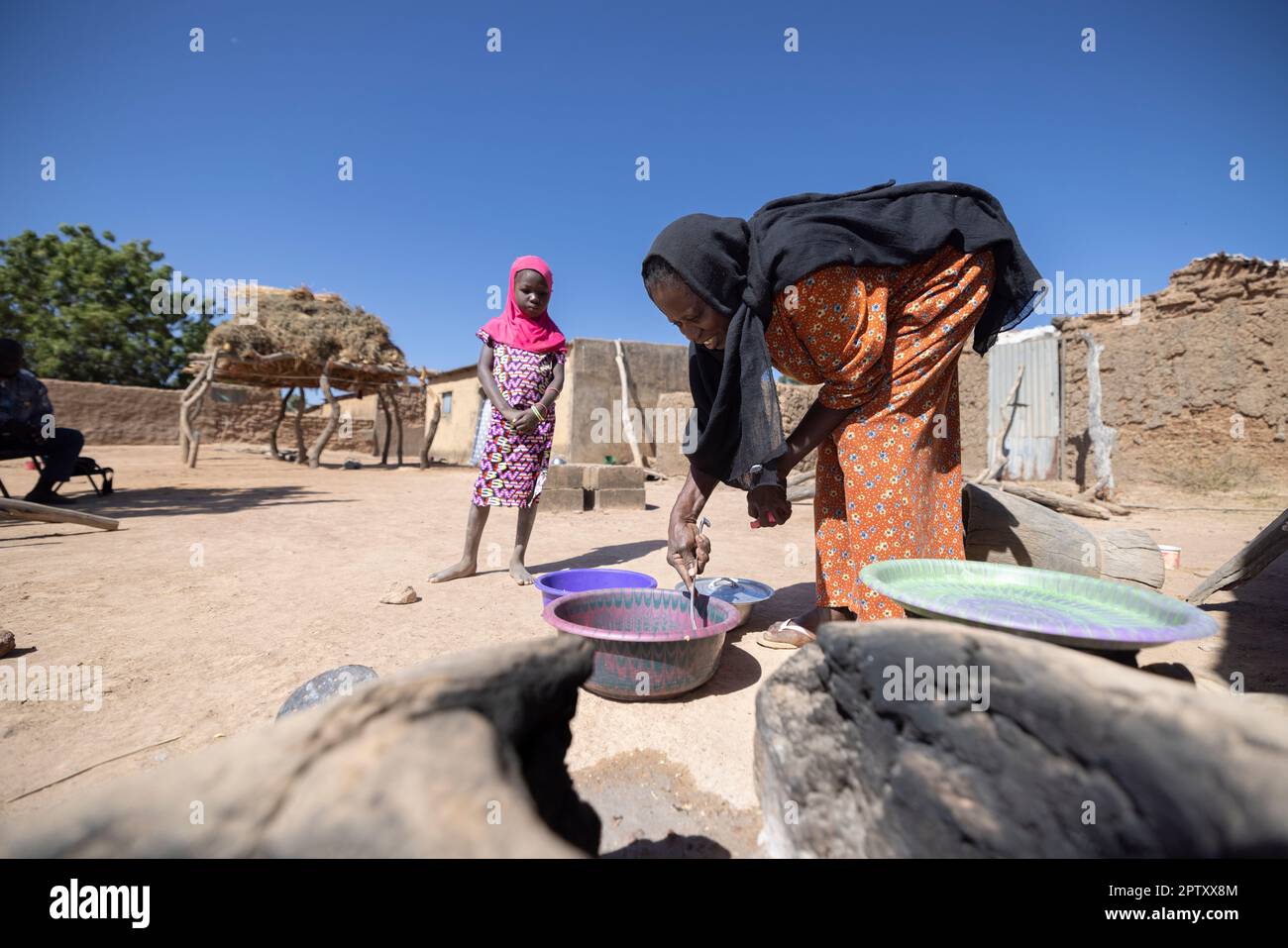 Eine ältere Frau kocht vor ihrem Haus in der Region Segou, Mali, Westafrika, über einem erdstämmigen, hausgemachten Herd. 2022 Dürre und Hungerkrise in Mali. Stockfoto