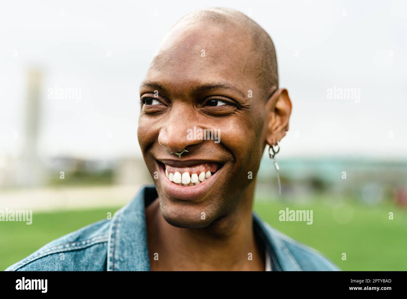 Fröhlicher afrikanischer Schwuler, der vor der Kamera posiert und lächelt Stockfoto