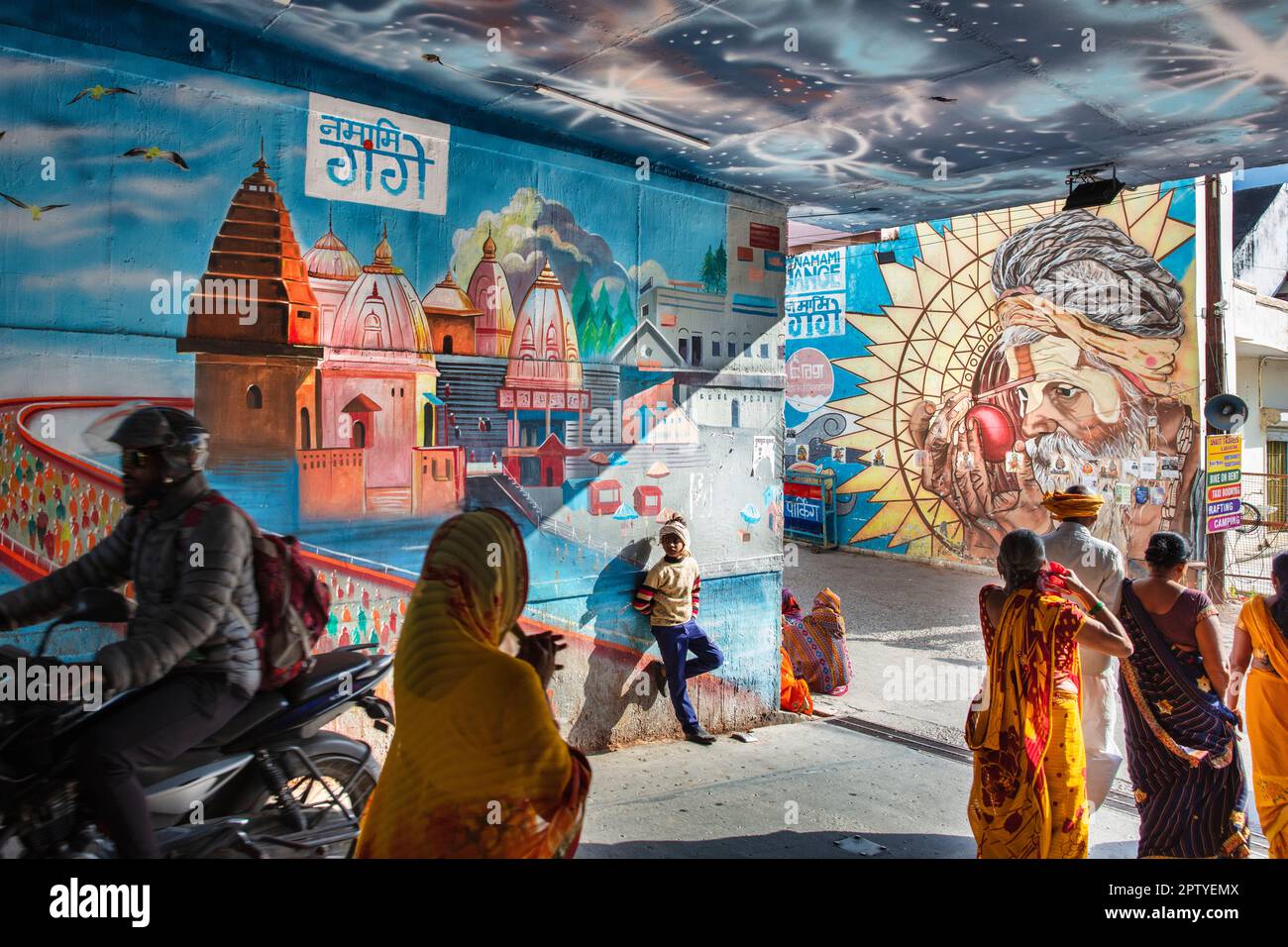 Indien, Uttarakhand, Rishikesh, Menschen vor Wandmalereien. Stockfoto