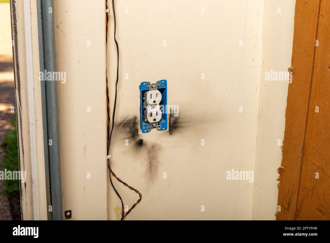 Steckdose mit Brandflecken an der Wand aufgrund eines Kurzschlusses. Stockfoto