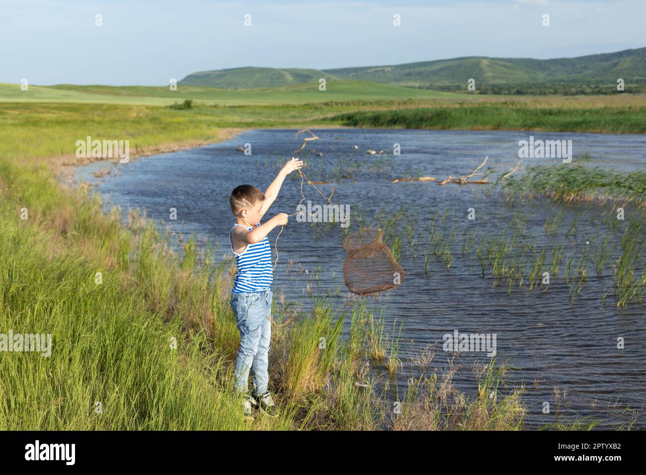 Hobby- und Freizeitaktivitäten während der Sommerferien. Kleiner Weißer Junge beim Angeln in den Sommerferien Stockfoto