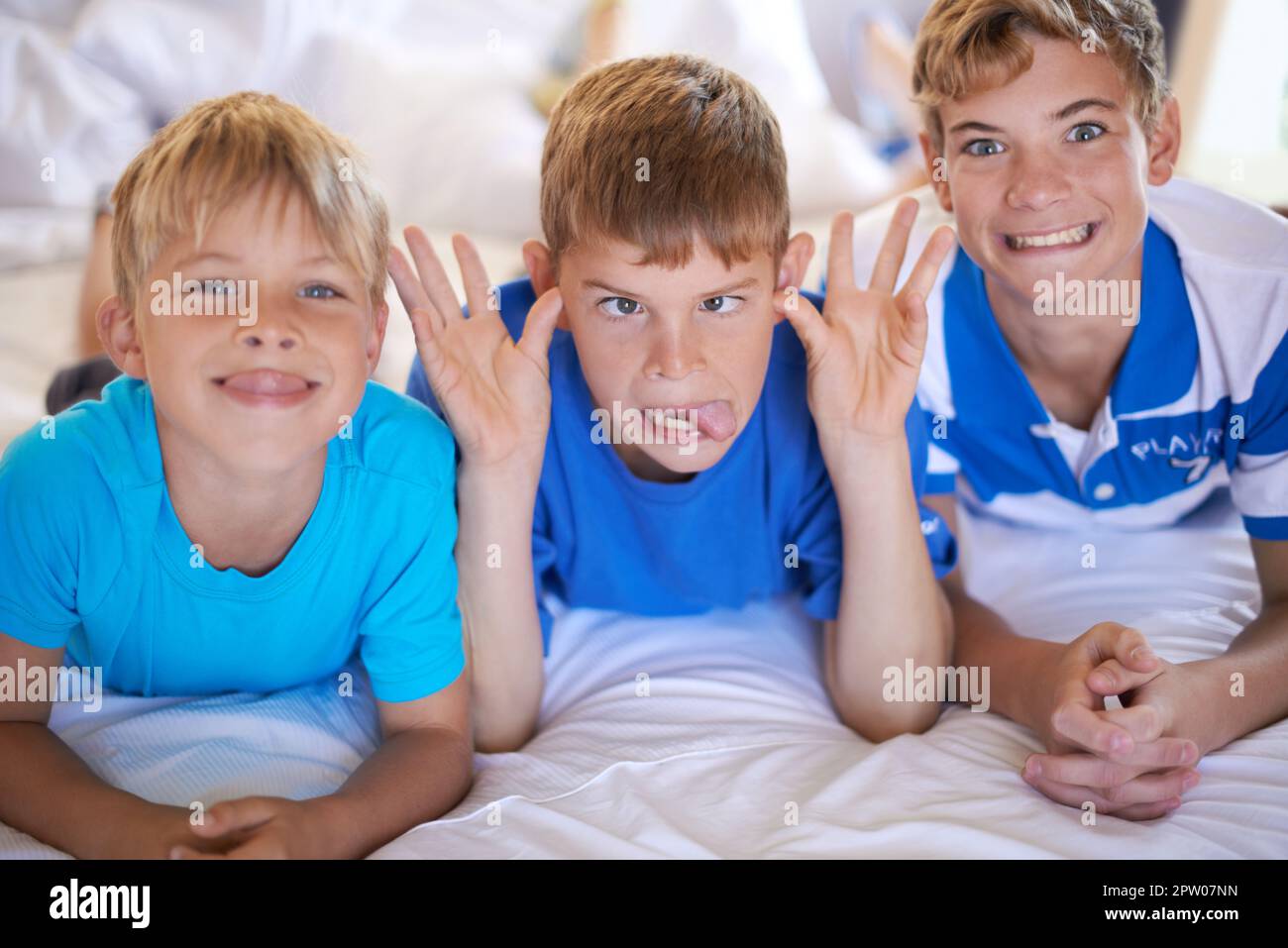Jungs werden Jungs sein. Drei Brüder ziehen lustige Gesichter vor die Kamera Stockfoto