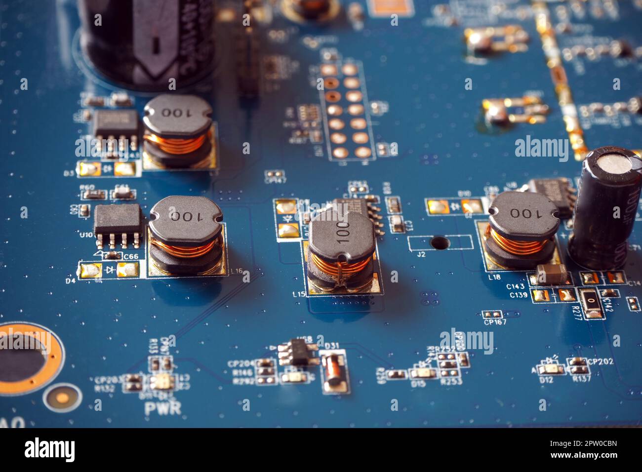 Elektronische Komponenten auf einer Hauptplatine. Spulen, Widerstände und Chips auf der Leiterplatte. Stockfoto