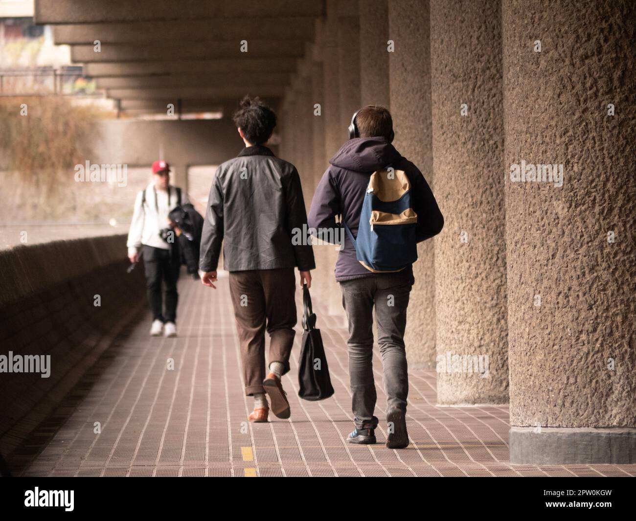 Fußgänger gehen den Andrewes Highwalk entlang, im Barbican Estate der City of London Stockfoto