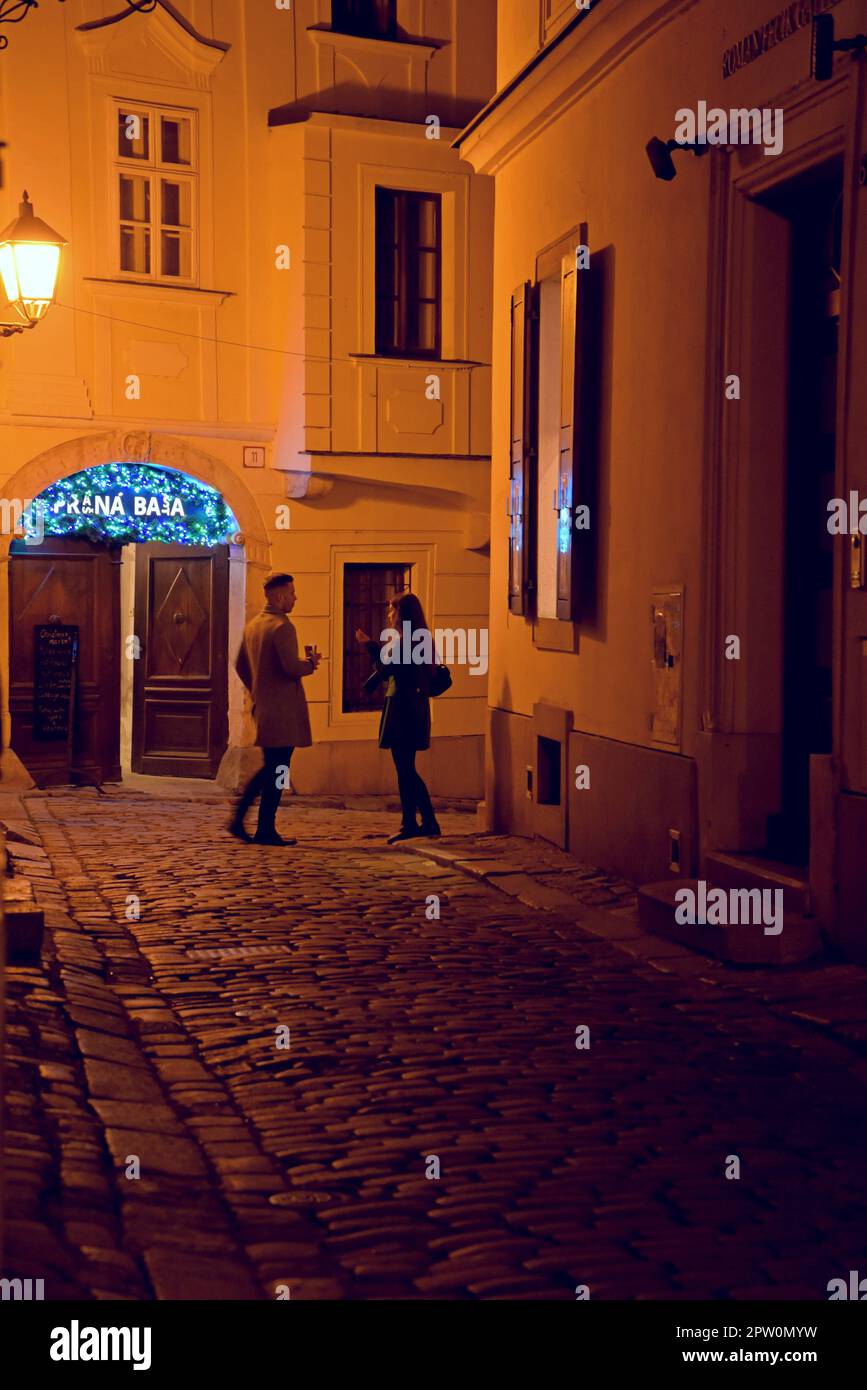 Menschen in einer gepflasterten Straße vor einem Nachtclub in der Altstadt von Bratislava, Slowakei Stockfoto