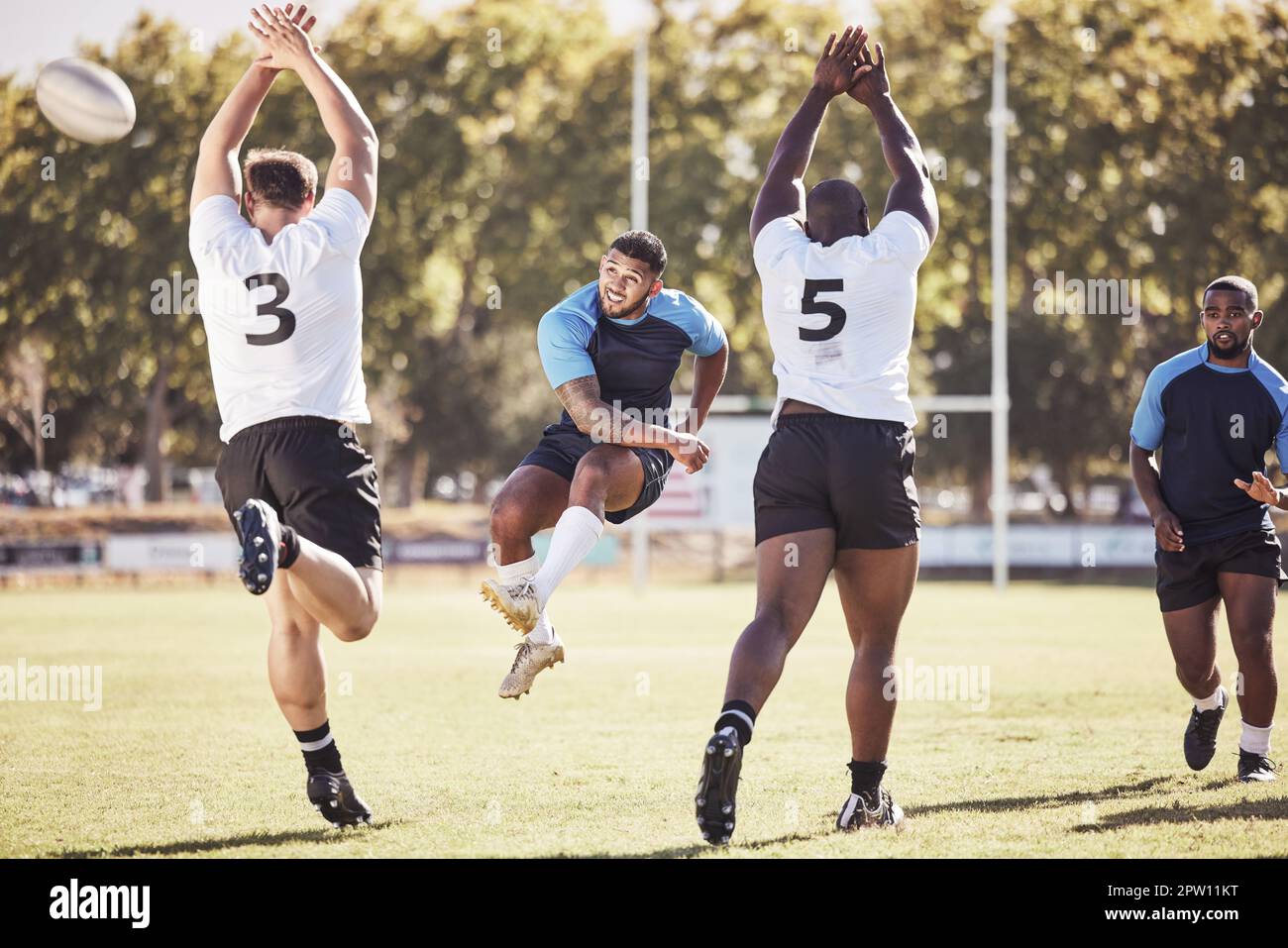 Rugby-Spieler mit gemischten Rassen versucht während eines Rugby-Spiels draußen auf dem Spielfeld einen dropkick. Hispanischer Mann, der für Berührung tritt oder versucht, drei P zu erreichen Stockfoto