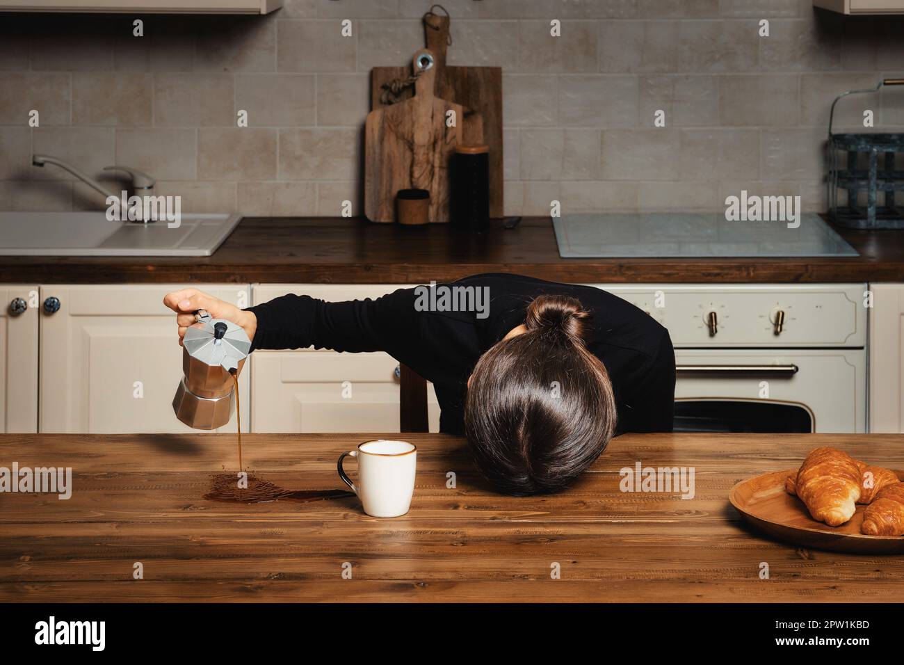 Schläfrige Frau, die morgens Kaffee auf den Tisch schüttet Stockfoto