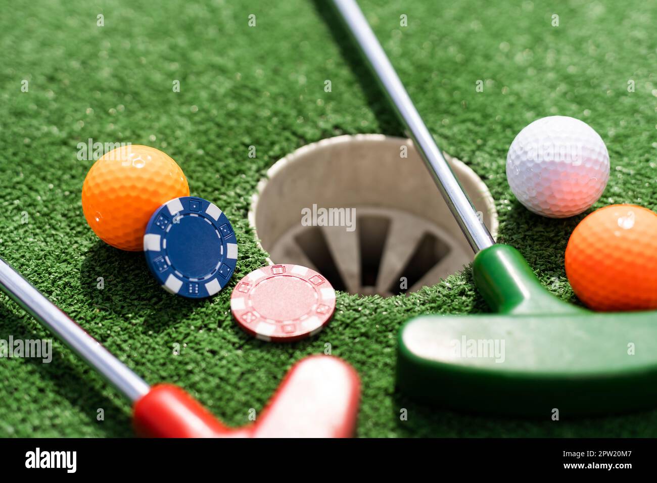 Casino-Chips und Golfausrüstung auf dem grünen Rasen. Stockfoto