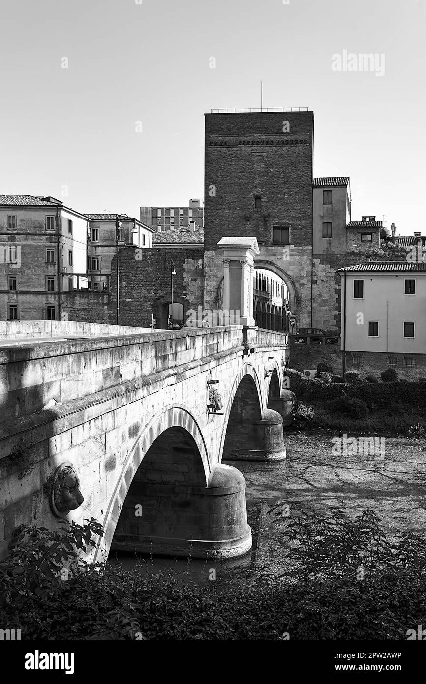 Steinbrücke am Bacchiglione River und historischer Turm mit Tor in Padua, Italien, monochrom Stockfoto