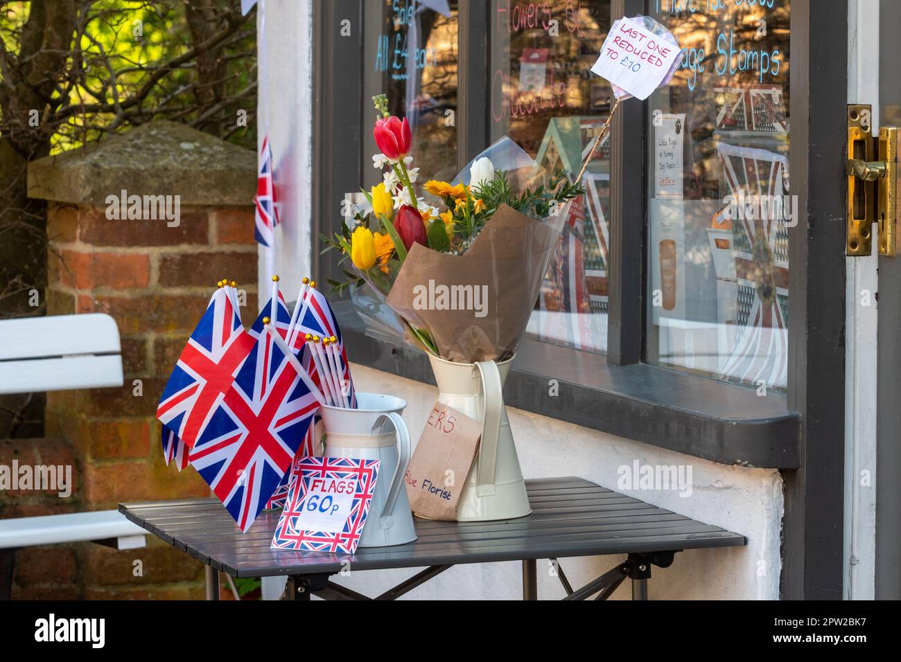 April 28. 2023, Union Jack Flags zum Verkauf vor einem Dorfladen in Selborne, Hampshire, England, Großbritannien, zur Krönung von König Karl III Stockfoto