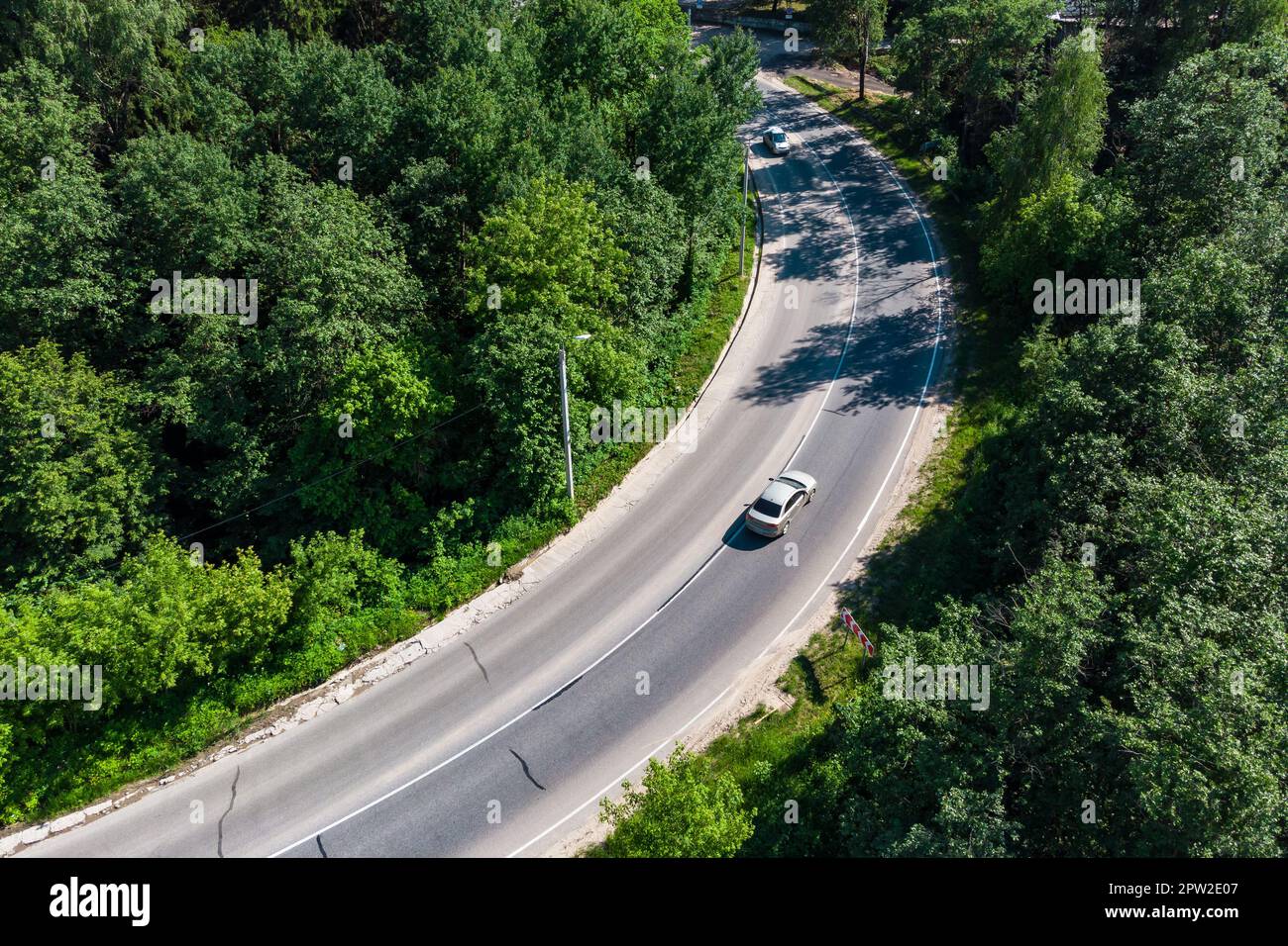 Draufsicht auf die Straße mit einer scharfen Kurve, in der sich das Fahrzeug bewegt Stockfoto