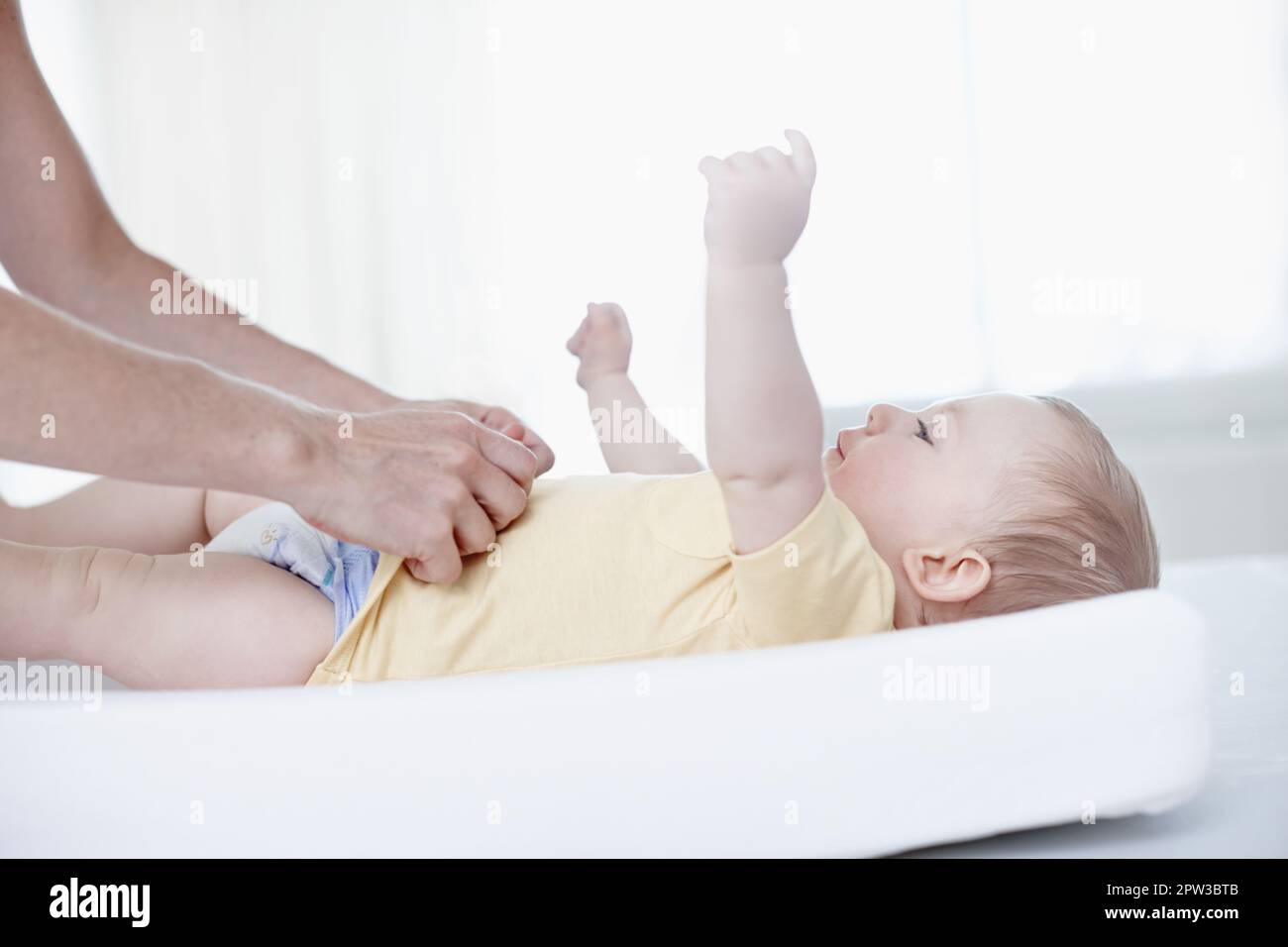 Kinder sind eine große Verantwortung. Ein süßer Junge, der von seiner Mutter verändert wird Stockfoto