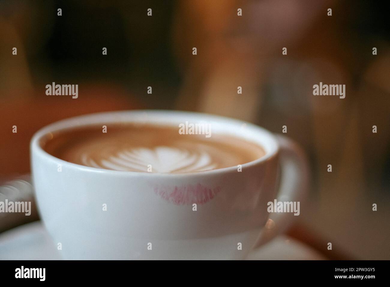Kaffeetasse mit Latte Art und Lippenstift-Muster Stockfoto