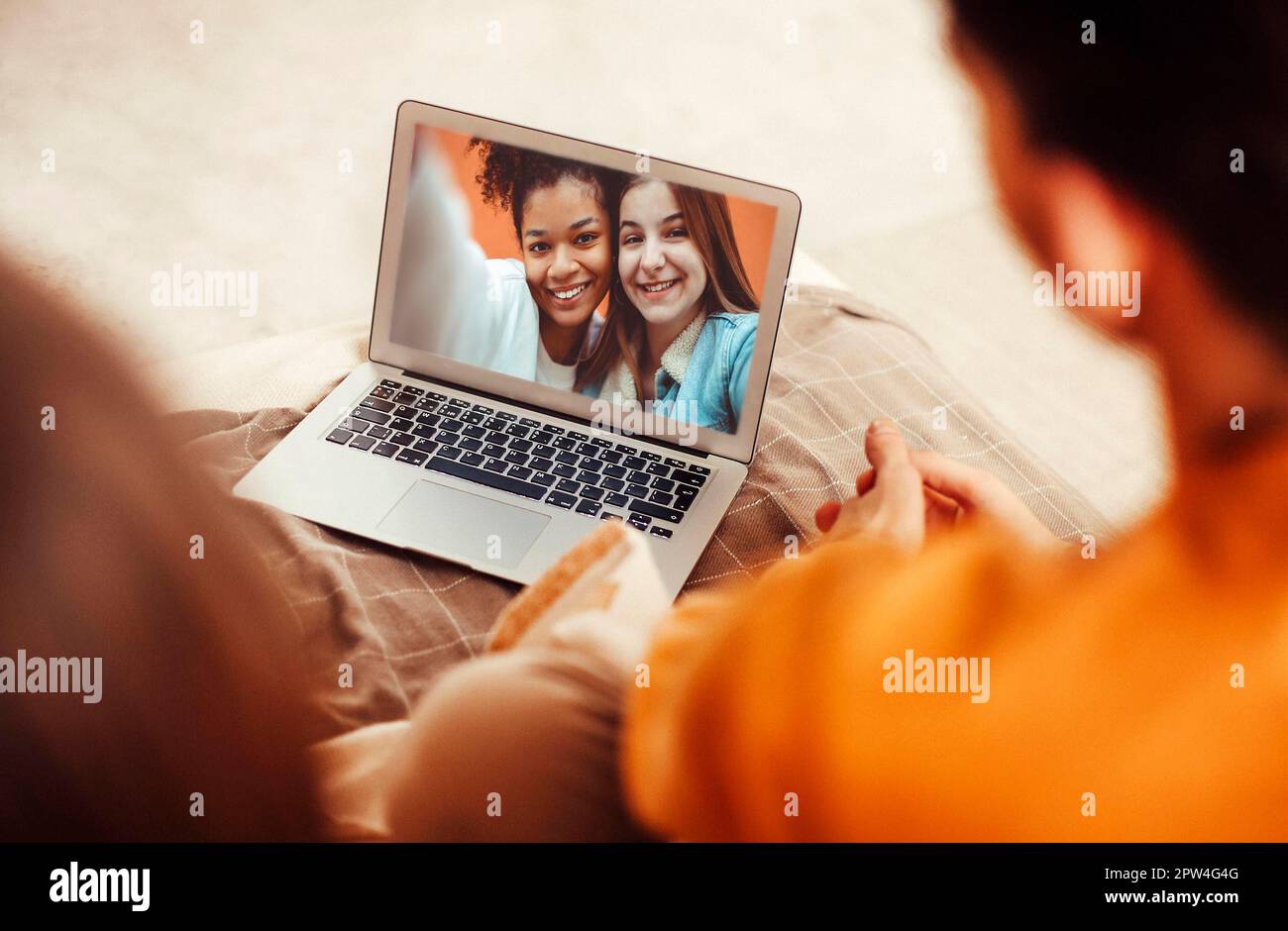 Porträt eines lächelnden jungen Paares mit Laptop auf dem Sofa zu Hause Stockfoto