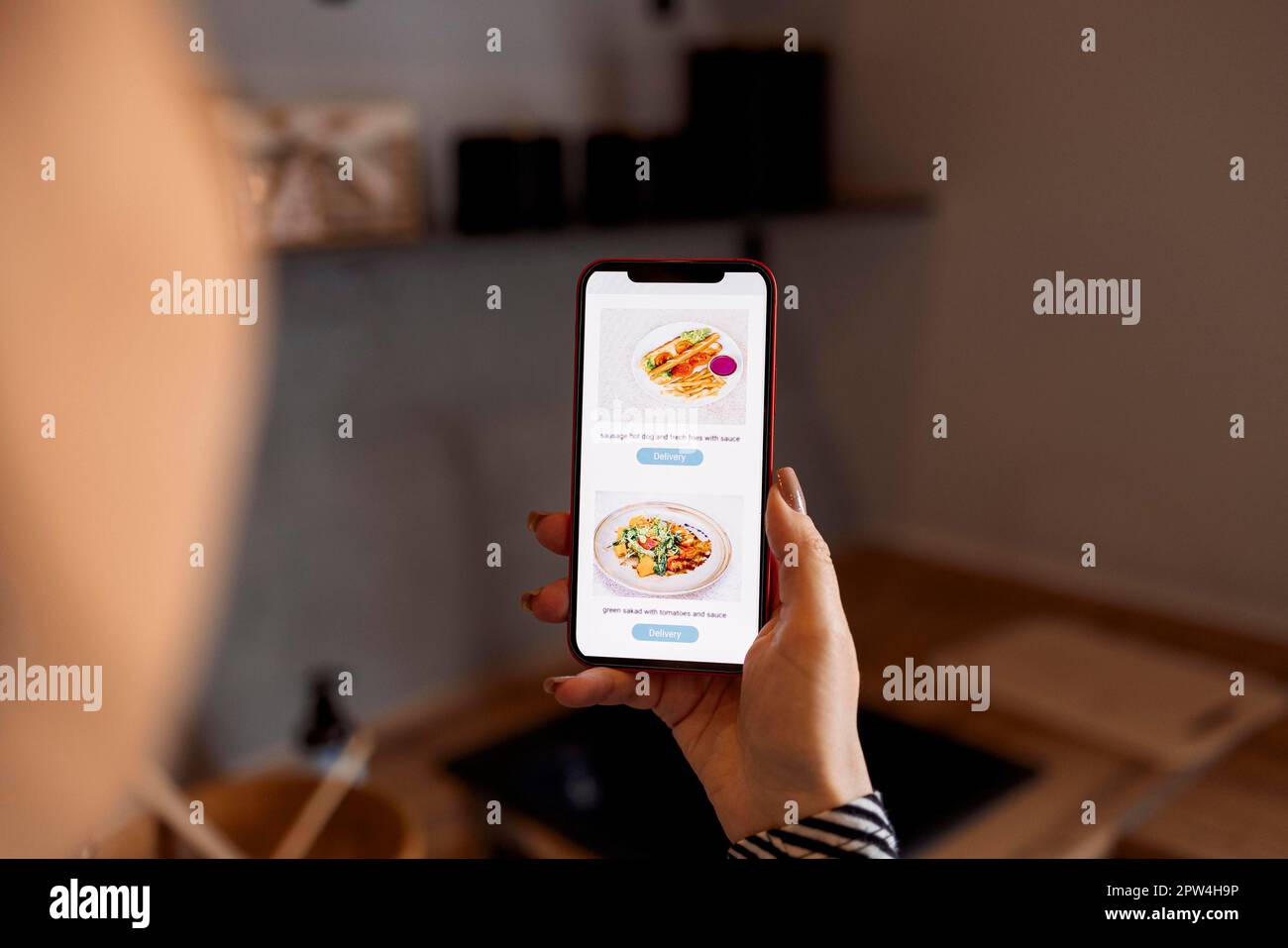 Glücklicher Käufer, der im Internet-Shop bestellt und die App auf dem Mobiltelefon verwendet, um dem Shop eine positive Bewertung zu geben. Frau mit Smartphone, bestellt Lieferung Stockfoto