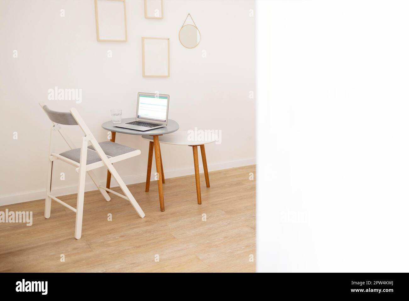 Hintergrund eines minimalen Home Office Arbeitsplatzes in einem modernen Apartment mit abstrakter Kunst und Kopierbereich. Modell Stockfoto