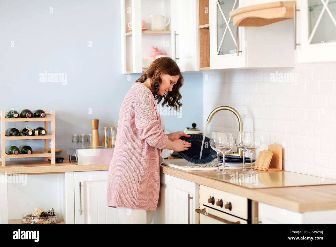 Seitenansicht der Hausfrau beim Abwaschen im Waschbecken Hausarbeiten in der Küche zu Hause Stockfoto
