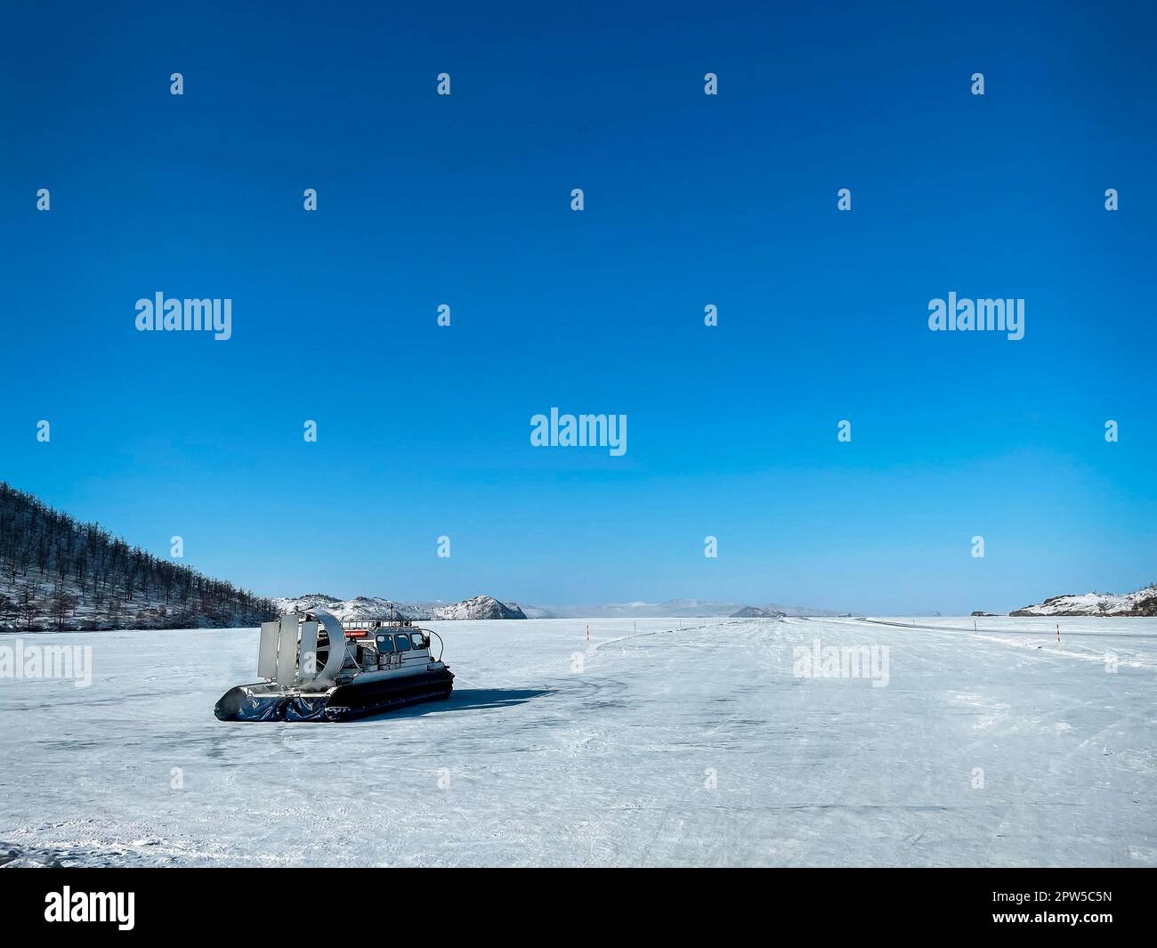 Khivus Wintertransport auf Eis, Luftkissenfahrzeug. Eis auf der Oberfläche des transparenten gefrorenen Sees Baikal. Blauer Himmel. Horizont. Horizontal. Baikal im Winter Stockfoto