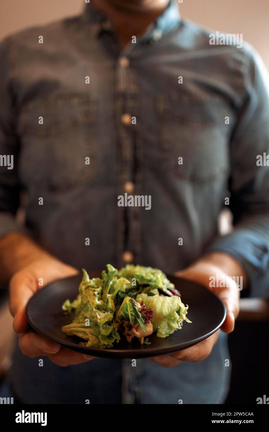 Gesunde Lebensweise. Mann Kochen Grüner Salat von romaine Kopfsalat. Gesunde Ernährung Konzept Stockfoto