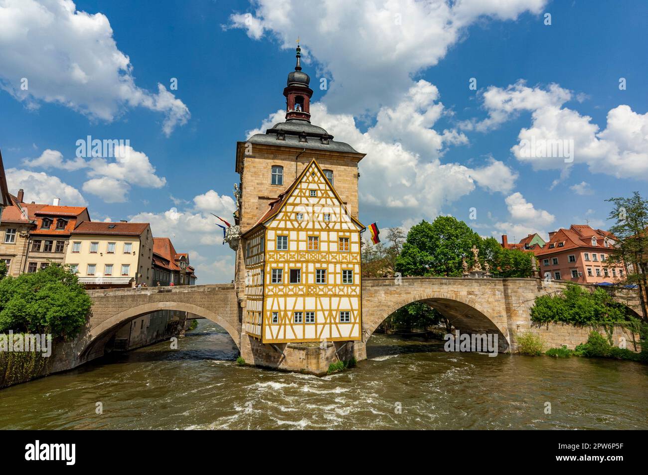 Das historische Rathaus von Bamberg auf einer Insel inmitten des Flusses Regnitz mit zwei Brücken, die es bei Sommerwetter mit der Küste verbinden Stockfoto