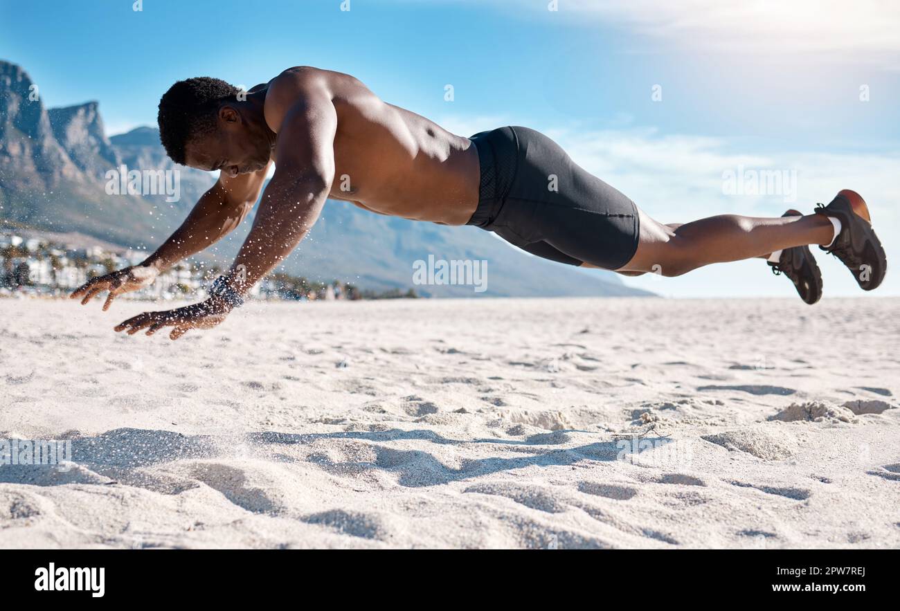 Fit jungen schwarzen Mann macht Plank Hold Übungen auf Sand am Strand am Morgen. Afroamerikanischer muskulöser männlicher Bodybuilder Athlet, der Bodyweigh macht Stockfoto